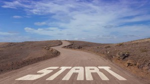 En grusvei strekker seg gjennom en gråbrun ørken. I starten av veien står det "Start". Veien ender i horisonten.